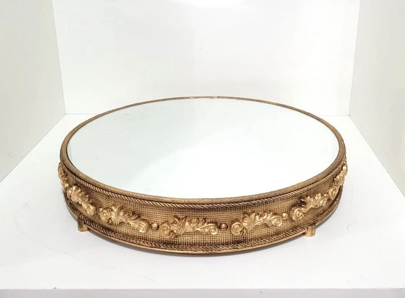 Boleira dourada ornamentada compondo a mesa do bolo